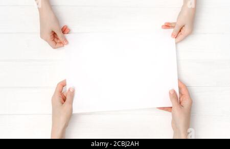 Mani che tengono un foglio di carta A4 vuoto per la progettazione Foto Stock