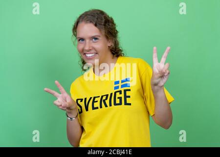 Blonde femmina tifosa di calcio svedese isolato su sfondo verde Foto Stock