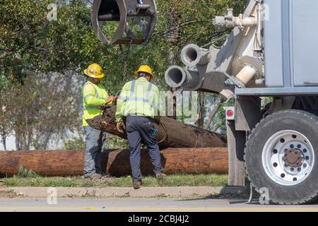 Cedar Rapids, Iowa, Stati Uniti. 13 agosto 2020. Un gruppo di servizi pubblici del Michigan lavora per ripristinare le linee di distribuzione ad alta tensione a Cedar Rapids, USA dopo che una massiccia tempesta di derecho ha colpito una vasta sezione dell'Iowa all'inizio della settimana. Credit: Keith Turrill/Alamy Live News Foto Stock