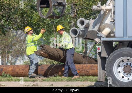 Cedar Rapids, Iowa, Stati Uniti. 13 agosto 2020. Un gruppo di servizi pubblici del Michigan lavora per ripristinare le linee di distribuzione ad alta tensione a Cedar Rapids, USA dopo che una massiccia tempesta di derecho ha colpito una vasta sezione dell'Iowa all'inizio della settimana. Credit: Keith Turrill/Alamy Live News Foto Stock