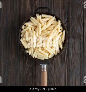 Penne pasta italiana in una padella, stile rustico. Vista dall'alto Foto Stock