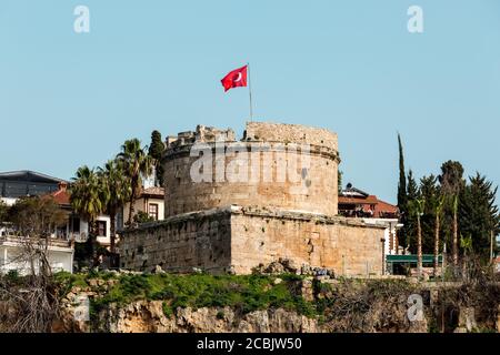 Antalya, Turchia - 22 febbraio 2019: Vecchia torre fortificazione con bandiera della Turchia nel centro storico di Kaleici ad Antalya. Foto Stock