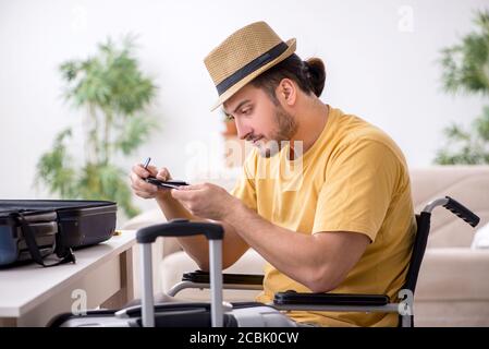 Giovane in sedia a rotelle che si prepara alla partenza Foto Stock