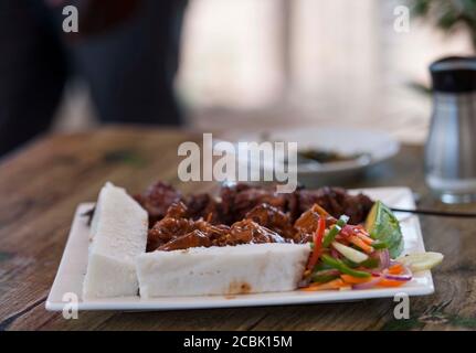 La Nsima, o ugali o posho, è un pasto principale per milioni di persone nell'Africa sub-sahariana. Mangiato popolarmente con choma di nyama, carne di capra o appena verdi Foto Stock