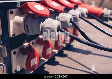 Collegare il cavo di alimentazione, molte prese con spine nere inserite da vicino. Elettricità in produzione. Foto Stock