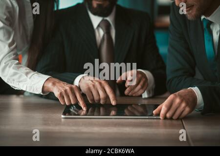 Lavoro di codorking. Uomini d'affari creativi che toccano con le dita il tablet digitale lavorando insieme a un nuovo progetto. Primo piano di mani umane. Oscurata Foto Stock