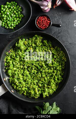 Ricetta di piselli ai funghi padella cotti e piselli in ciotola con pepe di scalogno alla menta e sale su una superficie di pietra nera vista dall'alto del keto food biologico Foto Stock