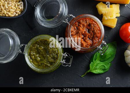 Pesto alla Genovese rosso e verde, salsa di basilico resh fatta in casa e cucina ricetta italiana ingredienti formaggio parmigiano, foglie di basilico, pinoli, olive Foto Stock