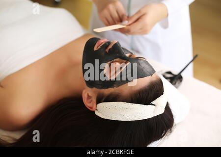 Concetto di Spa. Giovane donna con nutriente maschera facciale in un salone di bellezza, vicino fino Foto Stock