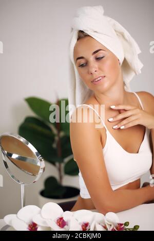 Giovane donna in un accappatoio, porta la bellezza nel bagno Foto Stock