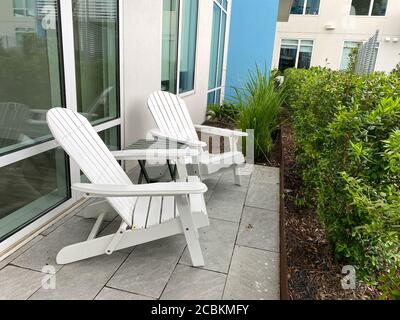 Due sedie adirondack sedute su un patio. Concetto di pace, consapevolezza, relax e stile di vita rilassato. Foto Stock