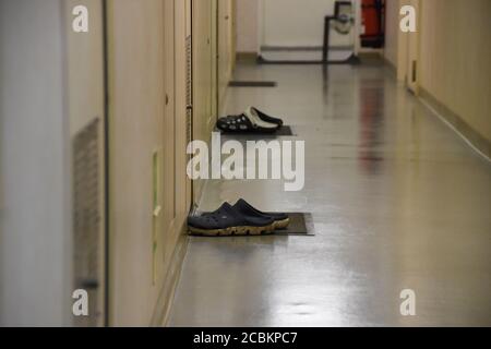 Le pantofole protettive con sdraiatura o posate ordinatamente in vicolo di ceretta dentro fronte delle cabine dell'equipaggio all'interno della sovrastruttura del container imbarcazione Foto Stock