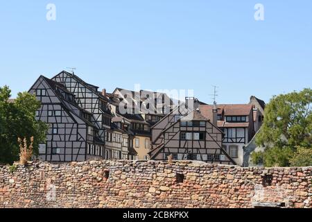 Edifici medievali e del primo Rinascimento a graticcio dietro il muro di mattoni rossi a Colmar, una città nella regione del Grand Est del Nord Francia. Foto Stock