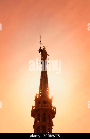 Statua della Madonna (la Madonnina) scolpita al sole sulla guglia più alta del Duomo di Milano Foto Stock