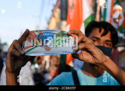 Guwahati, Assam, India. 14 agosto 2020. Un fornitore di strada che vende indiane giorno Independance maschera speciale prima del giorno Independence, in mezzo a pandemia di coronavirus a Guwahati. Credit: David Talukdar/ZUMA Wire/Alamy Live News Foto Stock