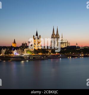 Paesaggio urbano sul lungomare con il Municipio, la Grande Chiesa di San Martino e la Cattedrale di Colonia (Koelner Dom) al tramonto, Colonia, Germania Foto Stock