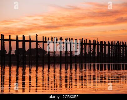 Silhouette di persone sul ponte U Bein al tramonto, Mandalay, Regione Mandalay, Myanmar Foto Stock