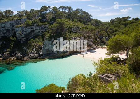 Vista in lontananza dei vacanzieri sulla spiaggia, Cala Macarelleta, Minorca, Spagna Foto Stock