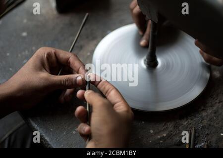 Primo piano di mani che lucidano i rubini in officina, Jaipur, Rajasthan, India Foto Stock