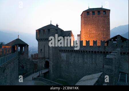 Ingresso e ponte levatoio della cinta muraria di Bellinzona illuminata di notte, Bellinzona, Ticino, Svizzera Foto Stock