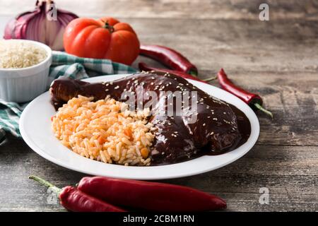 Tradizionale mole Poblano con riso in piastra su tavola di legno Foto Stock