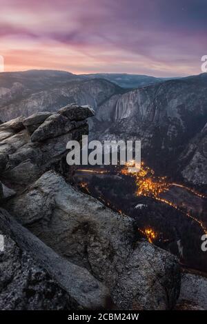 Montagne e luci della città nella valle al tramonto da Glacier Point, Yosemite National Park, Stati Uniti Foto Stock