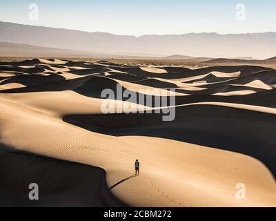 Lone Trekker sulle dune di sabbia di Mesquite Flat, Death Valley National Park, Furnace Creek, California, USA Foto Stock
