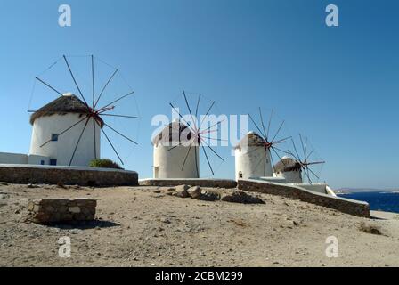 Fila di mulini a vento tradizionali sulla spiaggia, Mykonos, Cicladi, Grecia Foto Stock