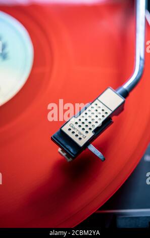 Disco in vinile rosso che gioca su un giradischi Foto Stock