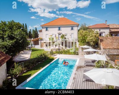 due persone nuotano nella piscina dell'hotel. Vista dall'alto, coppie di uomini e donne in piscina di casa vacanza di lusso nel Ardeche Francia Foto Stock