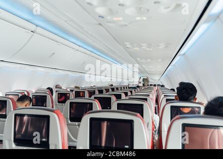 Interno di un aereo commerciale con poche persone sedute all'interno. Concetto di viaggio Foto Stock