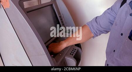 DISTRETTO KATNI, INDIA - 20 SETTEMBRE 2019: Mano dell'uomo che preleva contanti dal contatore di contanti della macchina ATM alla banca di stato dell'india. Foto Stock