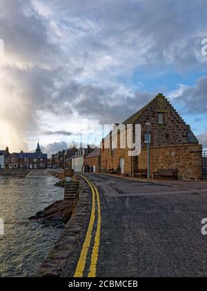 Una deserta Jubilee Street a Stonehaven in un freddo pomeriggio di febbraio, accanto ai porti e con nuvole scure sopra. Foto Stock