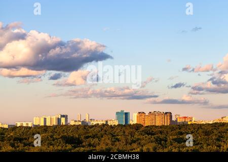 cielo blu e rosa tramonto con nuvole grigie e sopra città e verde foresta in estate soleggiata sera Foto Stock