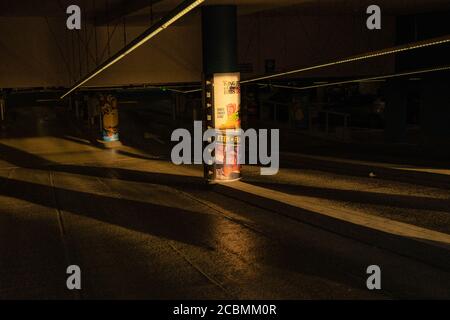 Raggi di luce solare durante l'ora d'oro che brillano in un garage quasi vuoto con alcune pubblicità. Foto Stock