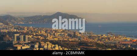 Panorama di Genova con la famosa lanterna simbolo della città nel centro del porto al tramonto. Golfo del Tigullio e portofino in backgr Foto Stock