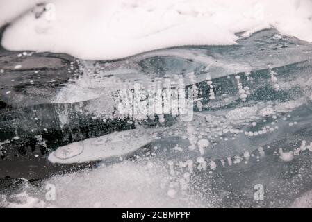 Bolle di gaz di metano congelate in ghiaccio limpido sul lago Baikal, Russia Foto Stock