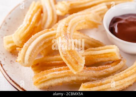 Churros con zucchero in polvere e salsa al cioccolato. Foto Stock
