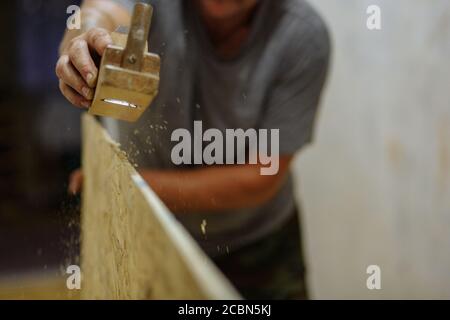Uomo che macina il legno. Uomo che lavora con legno. Riparazione domestica. Texture Foto Stock