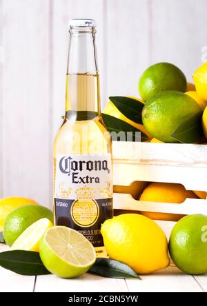 LONDON, Regno Unito - 27 Aprile 2018: Bottiglia di Corona Extra birra su sfondo di legno con freschi Limoni e limette . Corona, prodotta dal Grupo Modelo. Foto Stock