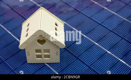 primo piano del modello di casa in legno su pannello fotovoltaico, concetto di ecologia ed energia verde, panorama Foto Stock