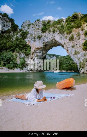 Donna sulla spiaggia vicino al fiume nel Pont d Arc Ardeche Francia, Ardeche Francia, vista dell'arco Narurale a Vallon Pont D'Arc nel canyon Ardeche in Francia Foto Stock