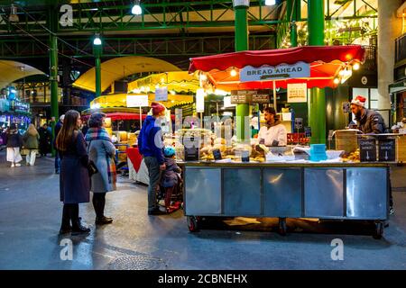Le persone che acquistano e il pane davanti si trovano al Borough Market, Londra, Regno Unito Foto Stock