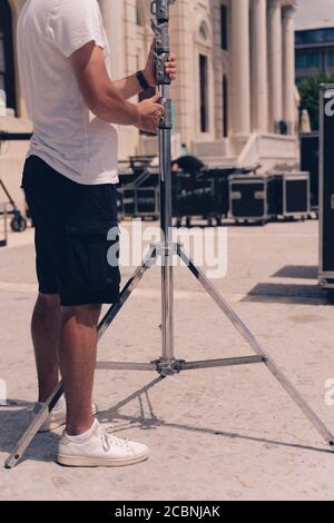 I tecnici dell'illuminazione impostano la luce per filmare i film al giorno. Foto Stock