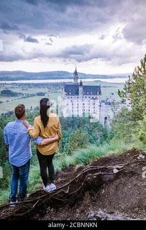 Uomini e donne in coppia visitano il Castello di Neuschwanstein. Splendida vista sul famoso castello di Neuschwanstein, la rinascita romanica del XIX secolo Foto Stock