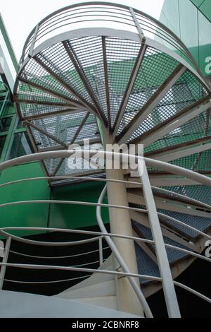 Immagine verticale di una scala a chiocciola di fronte ad un edificio verde. Foto Stock