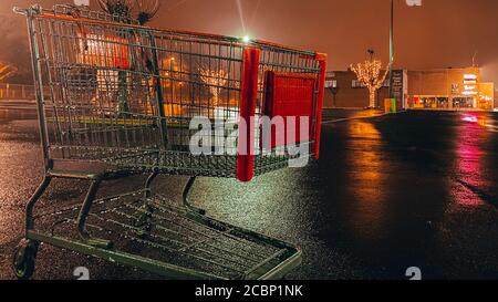ELKINS PARK, PENNSYLVANIA - MAR 10, 2020: Un carrello di shopping Lone in un parcheggio del centro commerciale in un giorno piovoso, le aziende stanno soffrendo come risultato di COVID-19. Foto Stock