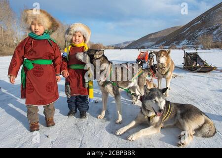 Bambini con Husky di fronte a slitta, Terelj, TUV aimag, Mongolia Foto Stock