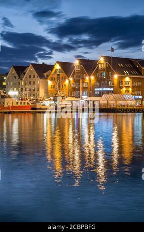 Fila illuminata di case al porto con riflessione in mare, notte polare, Tromsoe, Troms, Norvegia Foto Stock