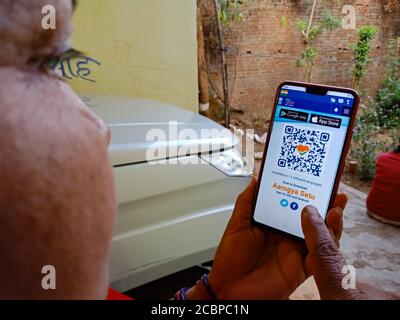 DISTRETTO KATNI, INDIA - 27 APRILE 2020: Una donna matura indiana ha visualizzato il codice a barre Aarogya Setu sullo schermo dello smartphone, per la valutazione del virus corona awaren Foto Stock